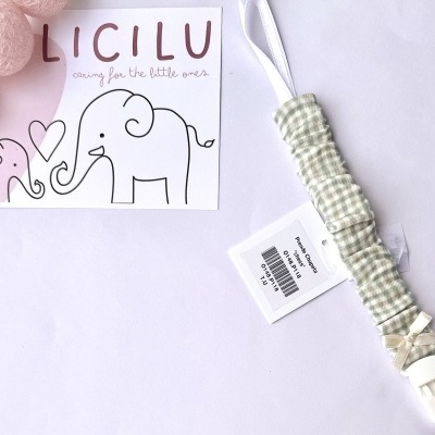 Prendedor de chucha em tecido verde às riscas creme com clip branco e cartão ilustrado com elefantes.