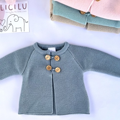 Casaco cinza em malha para bebé com botões de madeira e outros cardigans coloridos empilhados