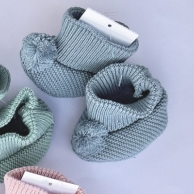 Sapatinhos de bebé em malha azul, verde e rosa claro com pompons e etiquetas