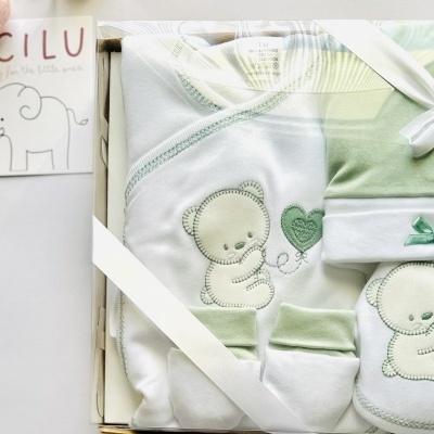Conjunto de roupa de bebê branco e verde com ursinho bordado em caixa com etiqueta