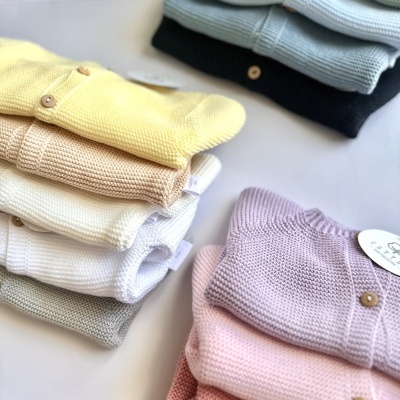 Pilhas de suéteres de malha coloridos com botões de madeira