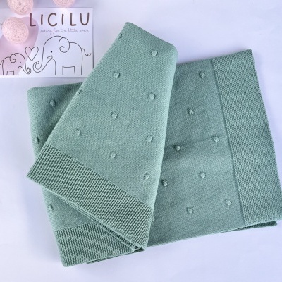 Manta de malha verde-pálido com relevos circulares