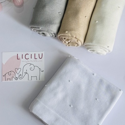 Mantas de malha com pompons em cores neutras e cartão LICILU
