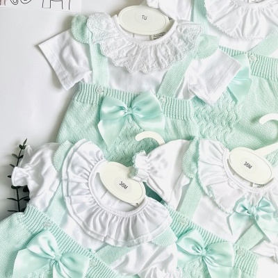 Roupas de bebé tipo body branco com folhos e calças verdes água de malha com laço