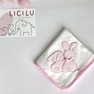 Babete branco com coelhinhos rosas e cartão com elefantes e texto LICILU