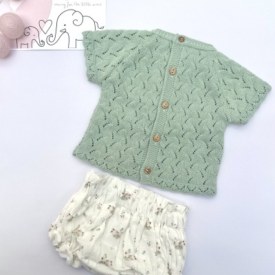 Conjunto de bebé verde e branco com botões de madeira e padrão de animais.