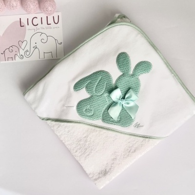 Toalha branca para bebé com aplicação de coelhos verdes e laço, com cartaz LICILU