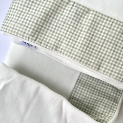 Colchão de bebé branco com interior xadrez cinza e branco e etiqueta azul com número