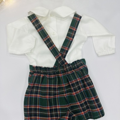 Roupa infantil com camisa branca de manga comprida e calções com alças xadrez verde e vermelho