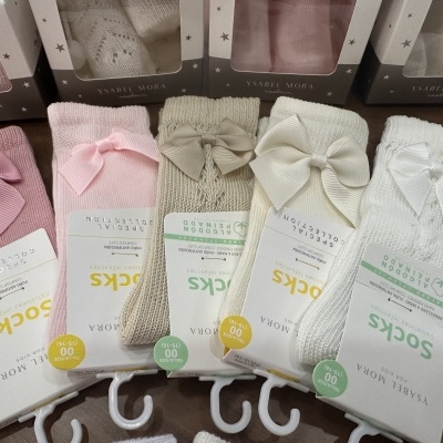 Meias de bebé Isabel Mora em rosa, bege e branco, com laços e etiquetas