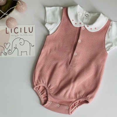 Conjunto de bebé com body branco e macacão rosa, ao lado cartolina com elefantes e texto LICILU.