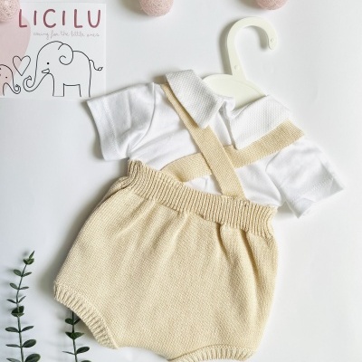 Roupa de bebé branca com calças de malha bege em cabide branco