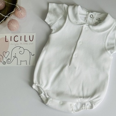 Body branco para bebé com botões, em tecido de malha texturada, junto a cartão com elefantes desenhados e texto LICILU