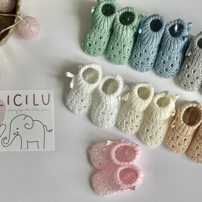 Sapatinhos de crochê para bebé coloridos alinhados ao lado de cartão com marca LICILU e desenho de elefantes