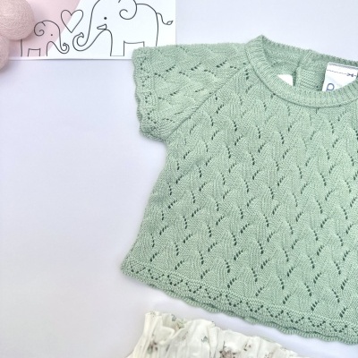 Conjunto de roupa de bebé verde claro e branco com padrão floral e cartão ilustrado