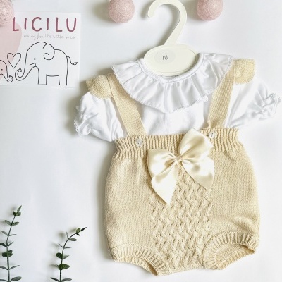 Conjunto de roupa para bebé com jardineira bege e camisa branca sobre fundo branco