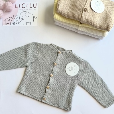 Casaco de malha cinza para bebé com botões de madeira, outros casacos em tons pastel empilhados ao lado