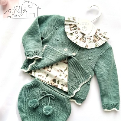 Conjunto de roupa de bebé em verde-água com gola estampada e detalhes em pompons.