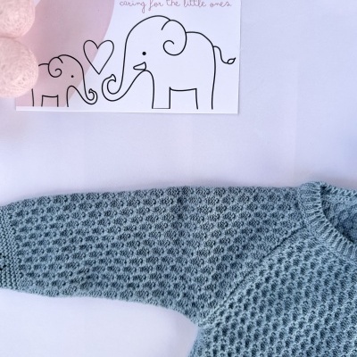 Manga de camisola cinzenta com padrão texturizado e cartaz com elefantes