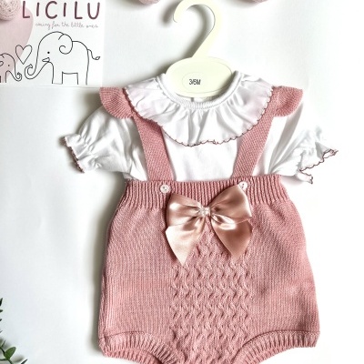 Conjunto de bebé em branco e rosa com jardineira e body.