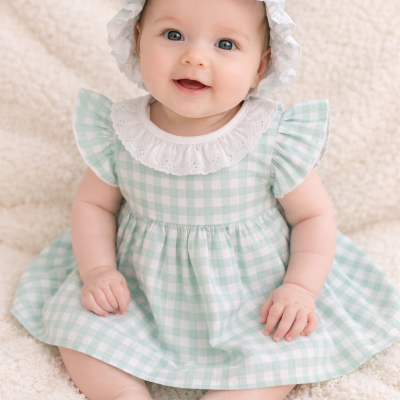 Bebé sentada com vestido e chapéu xadrez verde menta e branco com babados brancos