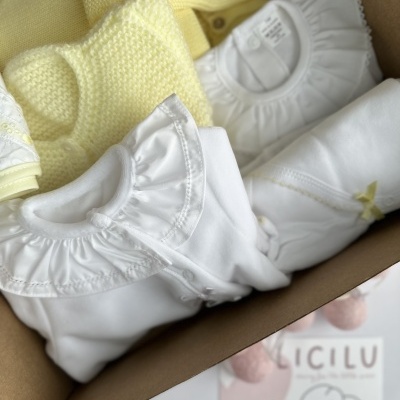 roupa de bebé branca e amarela em caixa com cartão LÍCILU
