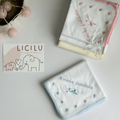 Fraldas de bebé com bordados e laços em diferentes cores e cartão da marca LICILU