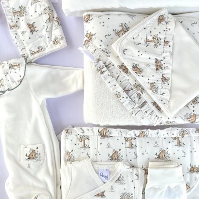 Conjunto de roupa e acessórios para bebé em algodão branco e estampado com animais castanhos.