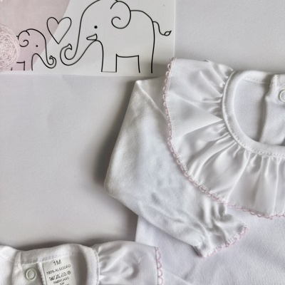 Roupas de bebé brancas com babado e cartão com elefantes