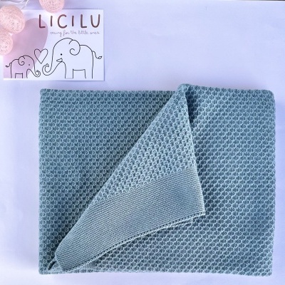 Manta azul texturizada com etiqueta LICILU e luzes decorativas rosas