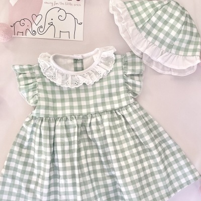 Vestido e chapéu de bebé aos quadrados verdes e brancos com folhos brancos.