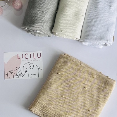 Quatro tecidos tricotados em tons pastel com pompons e cartão LÍCILU