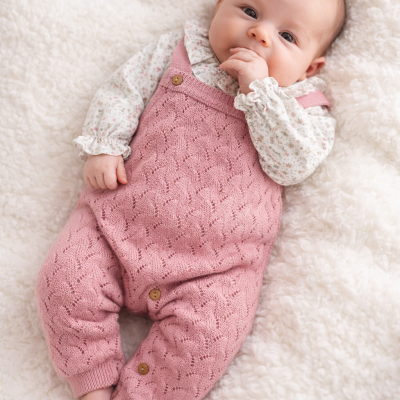 Bebé deitado com macacão rosa e camisa floral