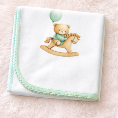 Manta de bebé branca com bordas verdes e desenho de ursinho num cavalinho com balão