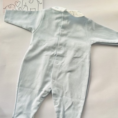 Macacão de bebé azul claro com gola branca e cartão LICILU ao fundo