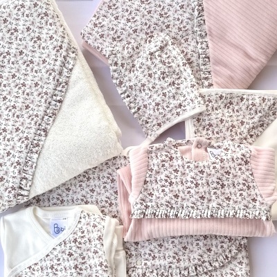 Conjunto de roupa de bebé floral e rosa com etiquetas visíveis
