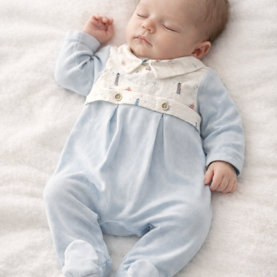 Bebé deitado a dormir com macacão azul claro e branco
