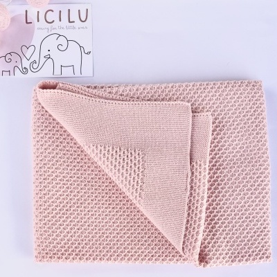Manta de malha rosa claro com borda lisa dobrada com cartão LICILU e desenhos de elefantes