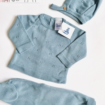Conjunto de roupa azul claro para bebé com camisa, calças e gorro, etiqueta Babl e embalagem com desenho de elefantes