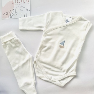 Conjunto de bebé branco com body bordado e calça com pés