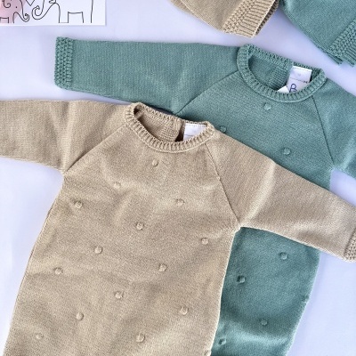 Conjunto de roupa de bebé em malha bege e verde água com padrão de pompons e gorro verde água com pompom