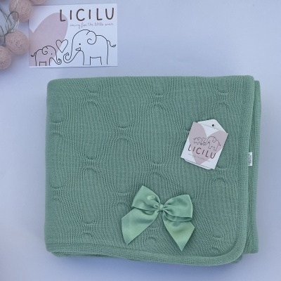 Manta verde para bebé com laço de cetim e etiqueta da marca LICILU