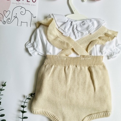 Conjunto de roupa de bebé branco e bege com cartão de marca e decoração