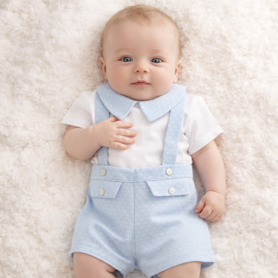 Bebé deitado com roupa azul clara de bolinhas e body branco