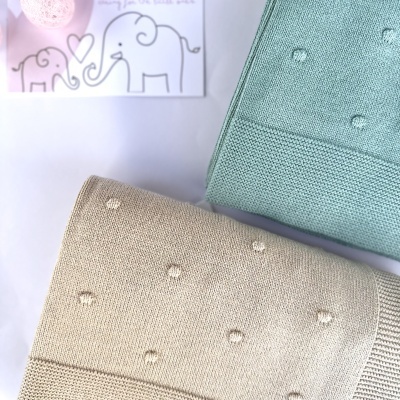 Mantas infantis de malha bege e verde água com padrão de pontos levantados e cartão com texto 'LICILU' e desenhos de elefantes.