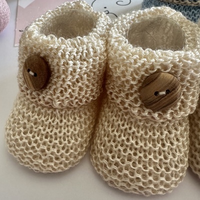 Sapatinhos de bebé em fio bege tricotado com botão de madeira