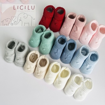 Sapatinhos de bebé em várias cores e cartão com texto LICILU