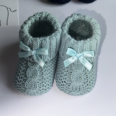 Botins de bebê azuis claros em malha com laços e padrão trançado
