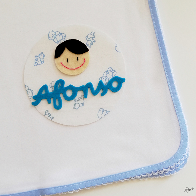 Fralda branca com borda azul claro e decoração com nome Afonso
