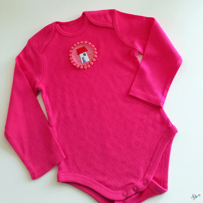 Body de bebé rosa com padrão texturizado e aplique redondo colorido